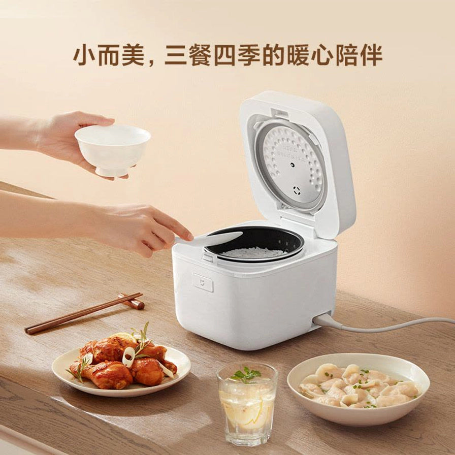 小米米家智能小饭煲2使用场景图，展示正在盛饭，配有“小而美，三餐四季的暖心陪伴”文字。