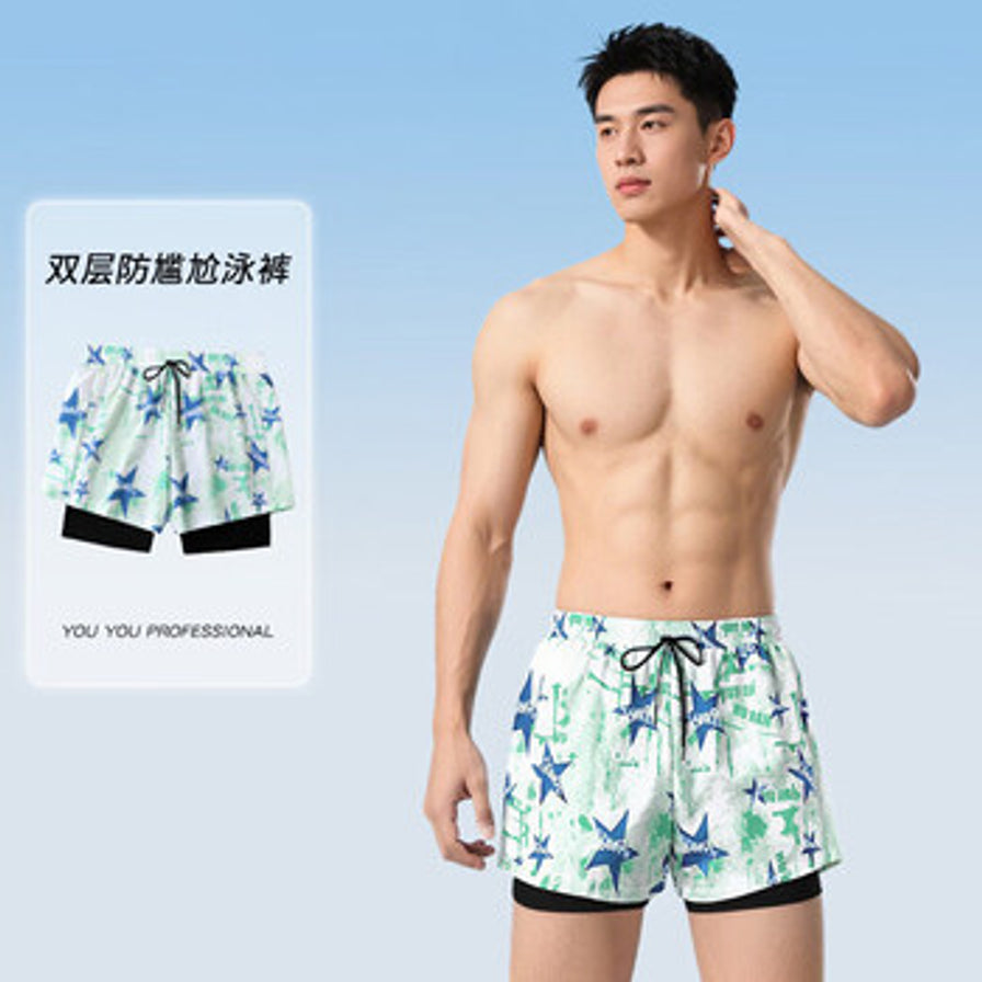 男士模特穿着特步平角泳裤的正面展示，背景为淡蓝色，左侧配有双层防尴尬泳裤的文字说明。