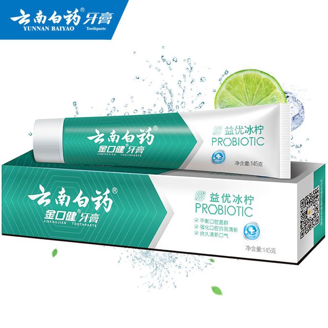 云南白药金口健益优冰柠牙膏，绿色包装设计搭配柠檬切片与水花飞溅效果，展示清新口味特征。