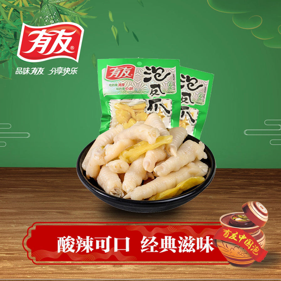 有友泡椒凤爪宣传海报，底部红框写有酸辣可口经典滋味，背景为绿色竹林风格，展示包装与实物。