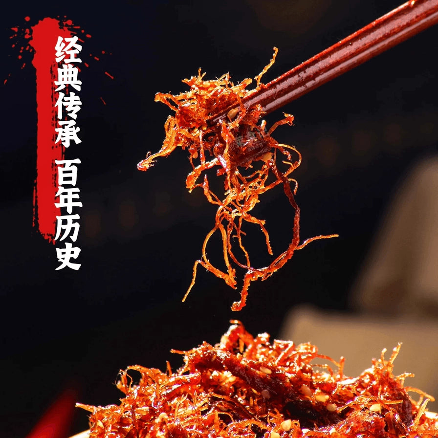 用筷子夹起的一簇灯影牛肉丝特写，丝丝分明，色泽红亮，背景带有经典传承百年历史的文字。