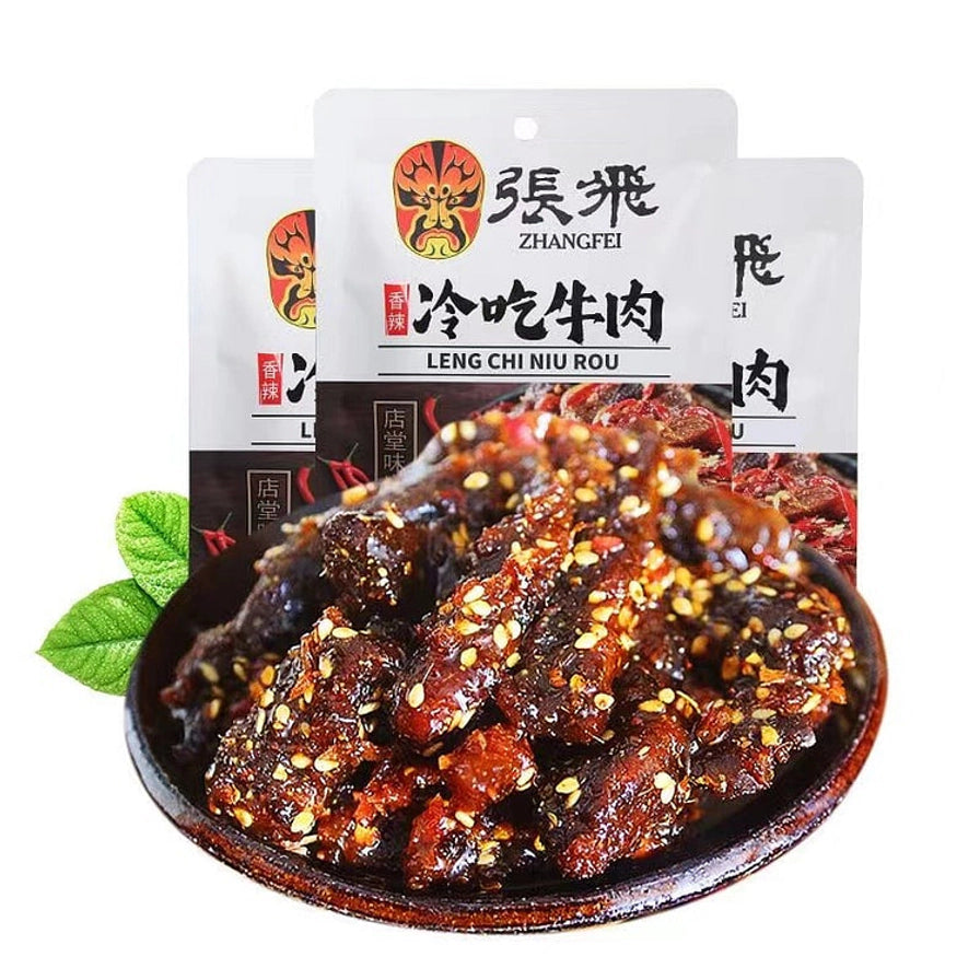 一盘撒满芝麻的香辣冷吃牛肉条，背景为张飞冷吃牛肉商品包装袋。