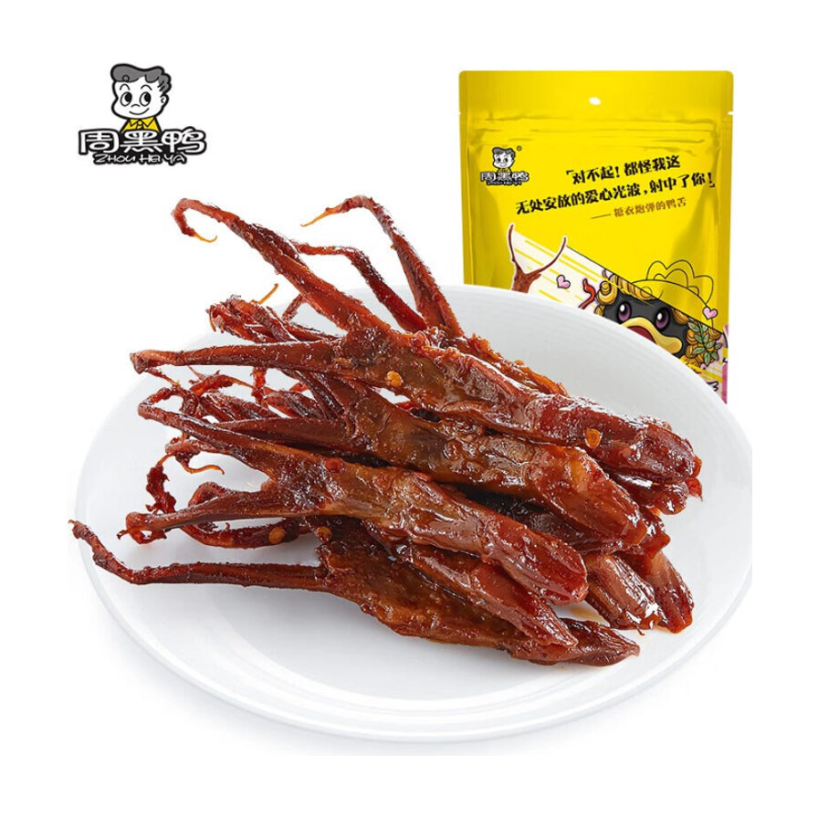 周黑鸭卤鸭舌，白盘盛放的深红色油亮鸭舌，背景为黄色真空包装袋。