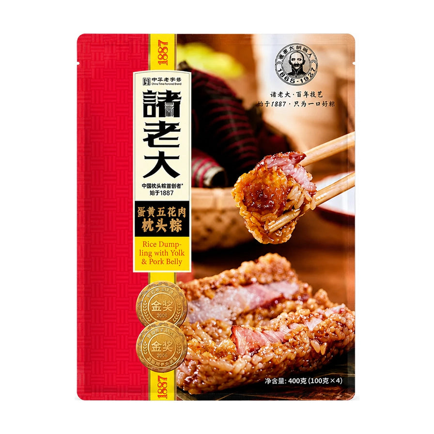 诸老大蛋黄五花肉枕头粽真空包装袋正面，展示品牌Logo、金奖标识及粽子切面特写，背景为筷子夹起粽子的展示图。